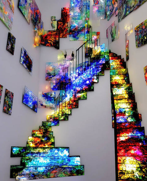 A picture of a stairway leading down to a house with colorful artwork