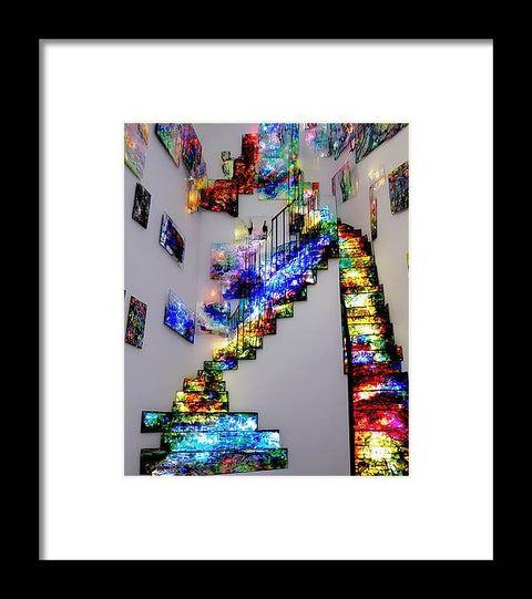 A colorful stair case filled with colored art hanging from the stairway