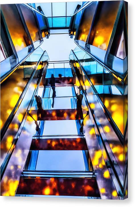 A man on an escalator in a building that has a wall covered in glass