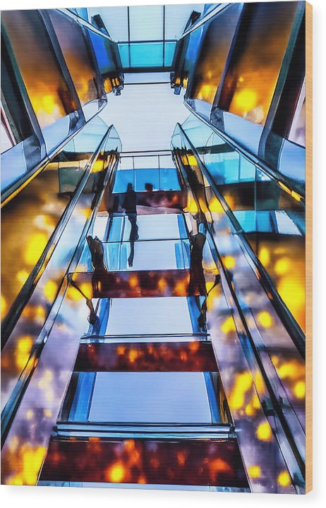 A silver and glass wall in an open elevator with a picture